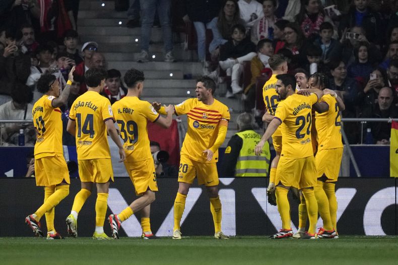 Robert Lewandowski, segundo desde la derecha, de Barcelona, celebra con sus compañeros después de marcar el segundo gol de su equipo durante el partido de fútbol de La Liga de España entre Atlético de Madrid y Barcelona en el estadio Metropolitano, en Madrid, España, el domingo 17 de marzo de 2024. (AP Foto/Bernat Armangue)