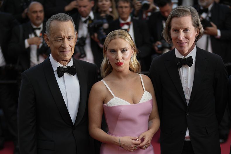 Tom Hanks, de izquierda a derecha, Scarlett Johansson y el director Wes Anderson posan al llegar al estreno de la película Asteroid City en la 76a edición del festival internacional de cine de Cannes, en el sur de Francia, el martes 23 de mayo de 2023. (Foto AP/Daniel Cole)