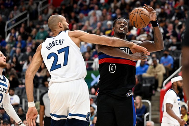 Jalen Duren, de los Pistons de Detroit, recibe una falta del francés Rudy Gobert, de los Timberwolves de Minnesota, en el partido del jueves 2 de abril de 2026 (AP Foto/Lon Horwedel)