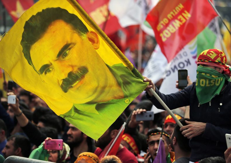 ARCHIVO – En esta foto de archivo del miércoles 21 de marzo de 2018, un joven sostiene una bandera con la imagen de Abdullah Ocalan, líder encarcelado del Partido de los Trabajadores de Kurdistán, o PKK, en Estambul, Turquía. (AP Foto/Lefteris Pitarakis, Archivo)
