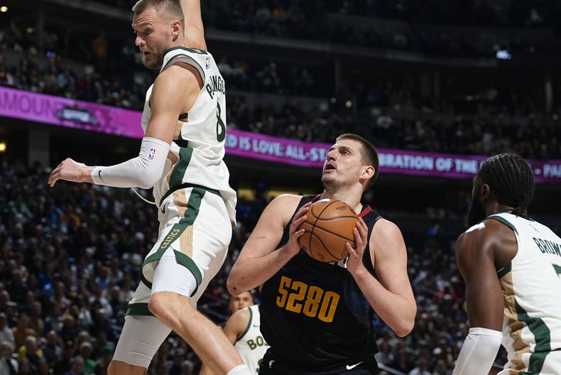 El serbio Nikola Jokic controla el balón detrás del letón Kristaps Porzingis, de los Celtics de Boston, en el encuentro del jueves 7 de marzo de 2024 (AP Foto/David Zalubowski)
