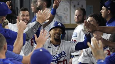 Mookie Betts, de los Dodgers de Los Ángeles, recibe la felicitación en la cueva tras batear un jonrón en el juego del martes 1 de agosto de 2023, ante los Atléticos de Oakland (AP Foto/Mark J. Terrill)