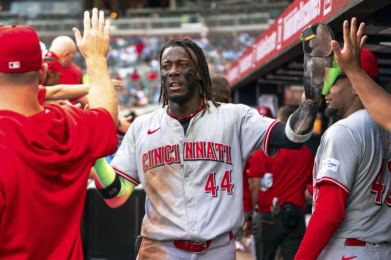 Elly De La Cruz (44), de los Rojos de Cincinnati, celebra con sus compañeros en el dugout después de anotar en la primera entrada contra los Bravos de Atlanta, el lunes 22 de julio de 2024, en Atlanta. (AP Foto/Jason Allen)