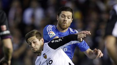 americateve | El volante de Real Madrid Xabi Alonso disputa un bal&oacute;n con Fede Cartabia, de Valencia (en primer plano) durante el partido que el equipo merengue gan&oacute; 3-2 el 22 de diciembre del 2013 en Valencia. Alonso sufri&oacute; la perforaci&oacute;n de