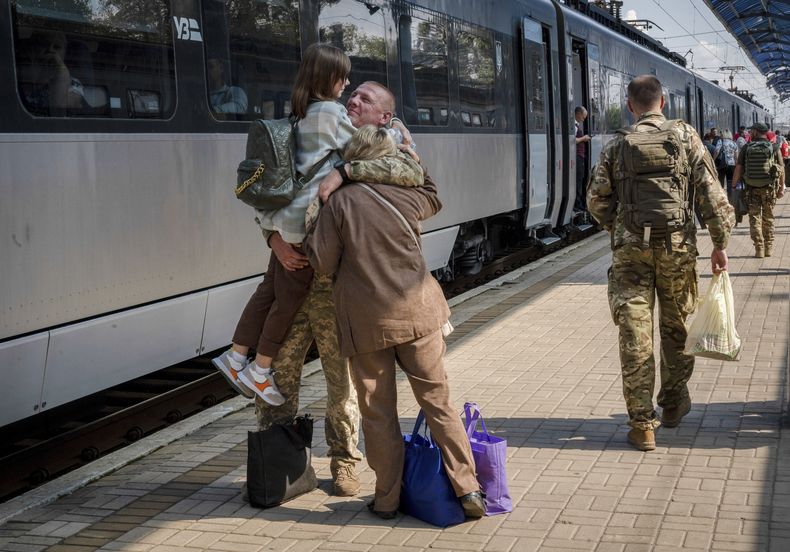 Un militar ucraniano abraza a su esposa y a su hija al despedirse de ellas para irse a combate en la estación de tren de Sloviansk, Ucrania, el 12 de septiembre de 2023. (Foto AP/Hanna Arhirova)