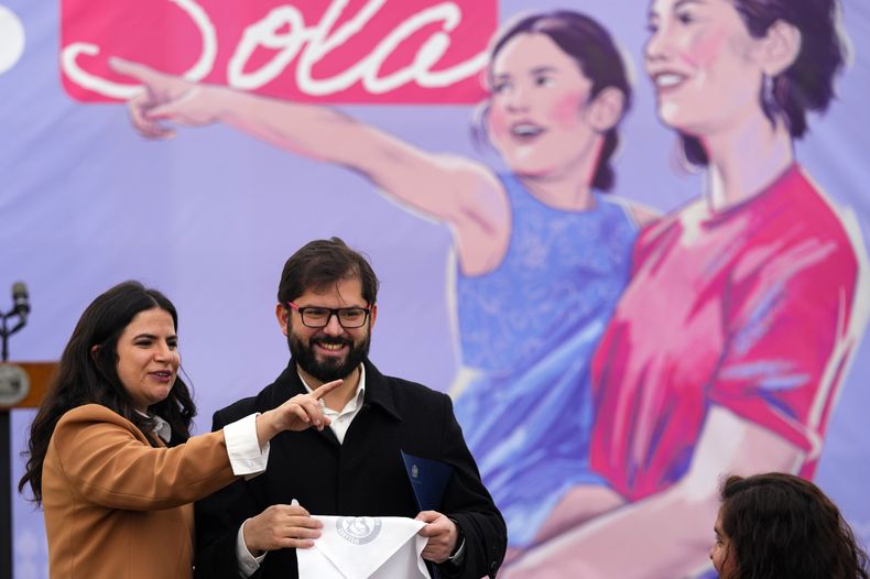 El presidente de Chile, Gabriel Boric, y la ministra de la Mujer, Antonia Orellana, asisten a un evento de promoción de la nueva Ley de responsabilidad parental y pago efectivo de las pensiones alimentarias frente al palacio presidencial de La Moneda en Santiago, Chile, el viernes 19 de mayo de 2023. La nueva ley, que entra en vigor el 20 de mayo, permite a los juzgados de familia cobrar devoluciones de impuestos, pensiones y congelar las cuentas bancarias de quienes incumplen con la pensión alimenticia. (Foto AP/Esteban Félix)