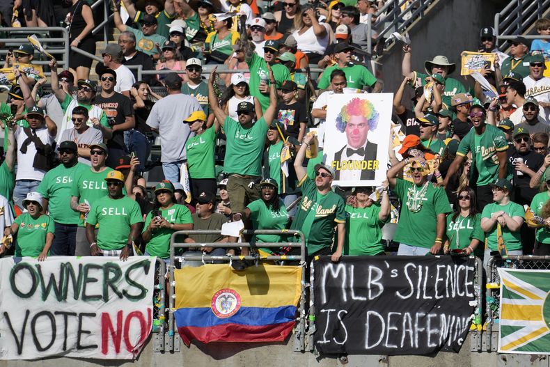 ARCHIVO - Foto del 5 de agosto del 2023, aficionados de los Atléticos de Oakland gritan y colocan pancartas pidiéndole al dueño que venda al equipo y lo mantenga en Oakland durante el encuentro ante los Gigantes de San Francisco. El miércoles 15 de noviembre del 2023, los dueños votarán el jueves sobre la posible mudanza del equipo a Las Vegas. (AP Foto/Jeff Chiu, Archivo)