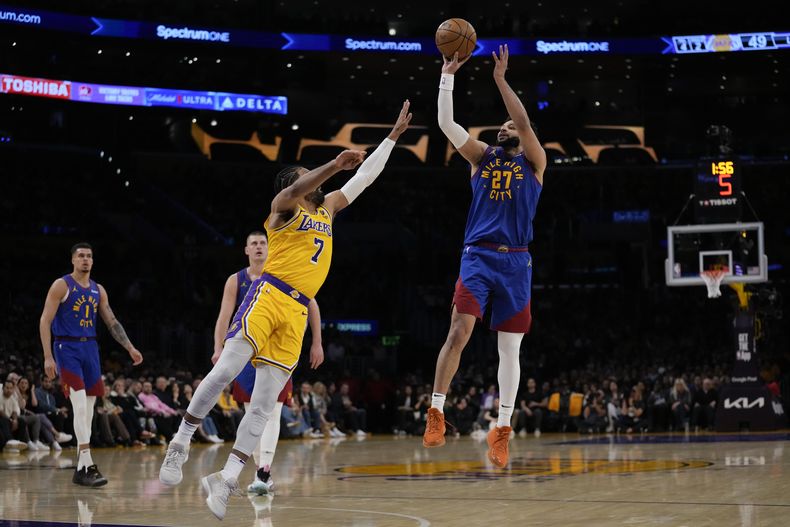 El base de los Nuggets de Denver Jamal Murray lanza el balón frente al base de los Lakers de Los Ángeles Gabe Vincent en el juego 3 de la primera ronda de la postemporada el jueves 25 de abril del 2024. (AP Foto/Ashley Landis)