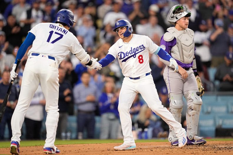 Kiké Hernández, de los Dodgers de Los Ángeles (centro), recibe la felicitación de Shohei Ohtani (izquierda) tras conectar un jonrón solitario, mientras el receptor de los Rockies de Colorado, Hunter Goodman, observa durante la tercera entrada de un partido de béisbol el martes 26 de mayo de 2026, en Los Ángeles. (Foto AP/Mark J. Terrill)
