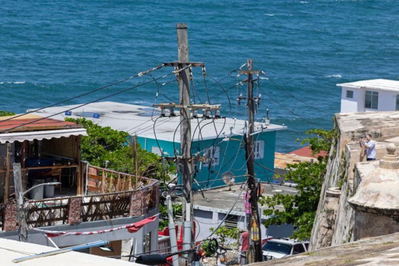 ARCHIVO - Líneas eléctricas y postes de servicios públicos frente al barrio de La Perla, en la costa del Viejo San Juan, Puerto Rico, el 15 de agosto de 2025. (Foto AP/Alejandro Granadillo, archivo)