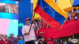 El presidente Nicolás Maduro ondea una bandera venezolana durante un acto de juramento para comités comunitarios organizados por el gobierno en el palacio presidencial de Caracas, Venezuela, el lunes 1 de diciembre de 2025. (Foto AP/Ariana Cubillos)