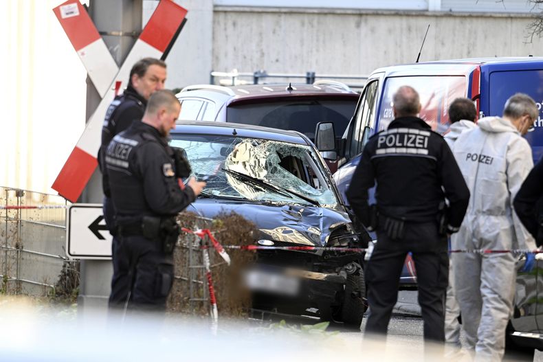 Policías permanecen al lado de un vehículo dañado en el centro de la ciudad de Mannheim, Alemania, el lunes 3 de marzo de 2025, tras un incidente fatal en que un auto arrolló a una multitud. (Boris Roessler/dpa vía AP)