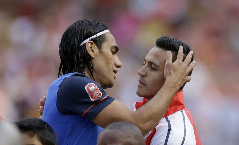 Alexis S&aacute;nchez del Arsenal (derecha) abraza a Radamel Falcao del M&oacute;naco previo a un partido amistoso en Londres el domingo 3 de agosto de 2014. (AP Foto/Matt Dunham)