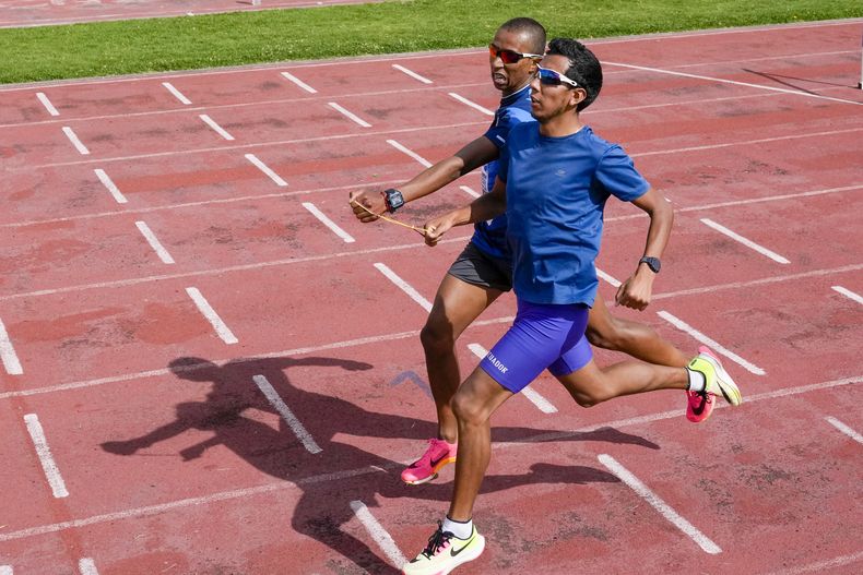 El atleta ecuatoriano Jimmy Caicedo (adelante) y su guía Daniel Taramuel entrenan en Quito el jueves 13 de junio de 2024, con miras a su participación en los Juegos Paralímpicos (AP Foto/Dolores Ochoa)