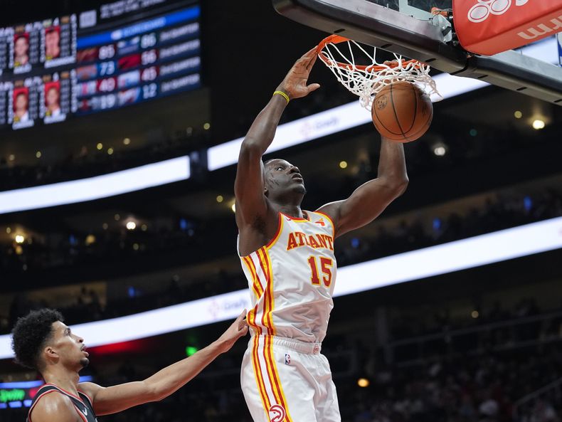 Clint Capela, de los Hawks de Atlanta, encesta delante de Shaedon Sharpe, de los Trail Blazers de Portland, en el encuentro del miércoles 27 de marzo de 2024 (AP Foto/John Bazemore)