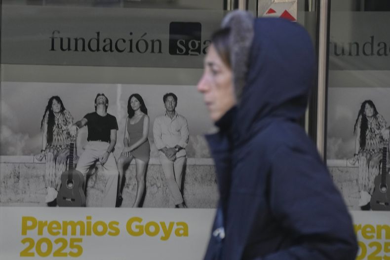 Una mujer pasa junto a carteles que anuncian a los finalistas de los premios Goya en un cine de Madrid, España, el miércoles 5 de febrero de 2025. (Foto AP/Paul White)