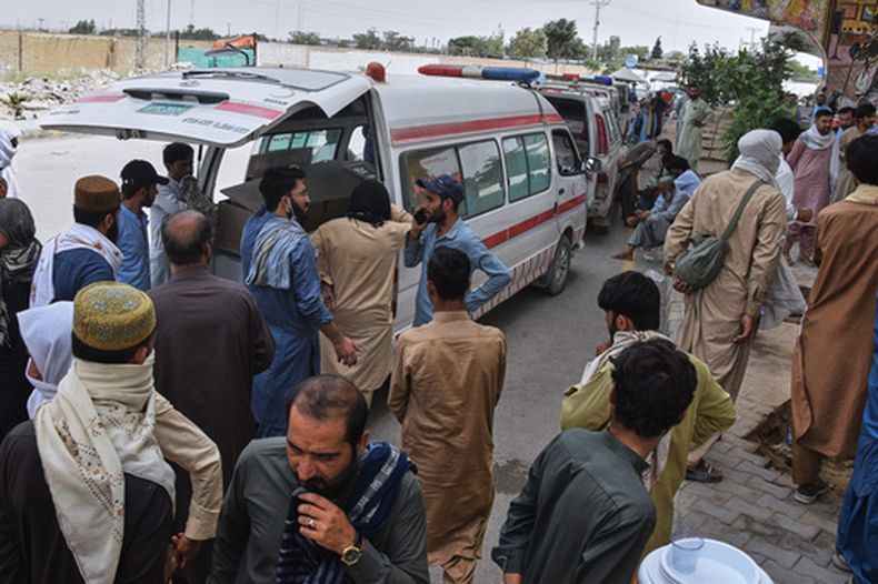 Dolientes se reúnen junto a las ambulancias que transportan los ataúdes de varios agentes de policía —secuestrados a principios de esta semana y posteriormente asesinados por insurgentes— en medio de una protesta a la vera de una carretera en Quetta, Pakistán, el jueves 9 de julio de 2026. (Foto AP/Arshad Butt)