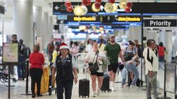 Una empleada de American Airlines con un gorro de Santa Claus camina por el Aeropuerto Internacional de Miami, el 24 de diciembre de 2024, en Miami. (AP Foto/Rebecca Blackwell)