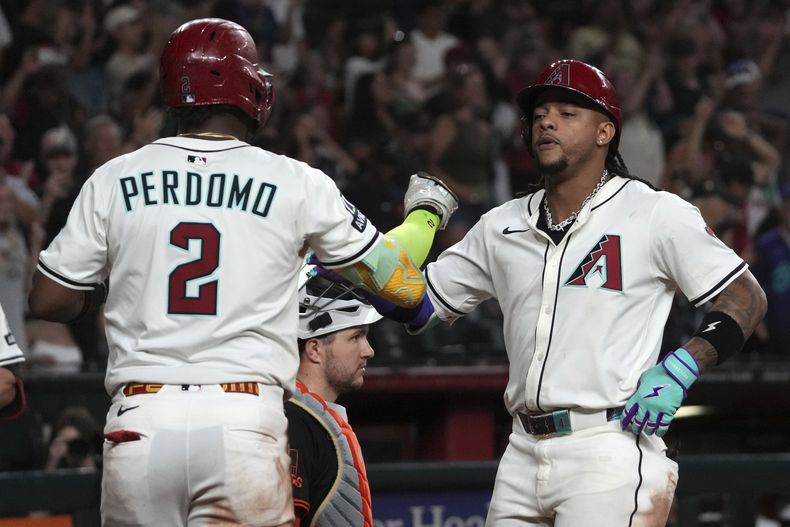 Los dominicanos Ketel Marte y Geraldo Perdomo, de los Diamondbacks de Arizona, festejan luego que el segundo conectó un jonrón ante los Gigantes de San Francisco, el miércoles 2 de julio de 2025 (AP Foto/Rick Scuteri)