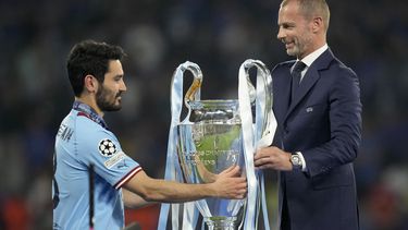 El presidente de la UEFA Aleksander Ceferin entrega el trofeo al capitán del Manchester City Ilkay Gundogan tras su victoria en la final de la Liga de Campeones ante el Inter de Milán, el sábado 10 de junio de 2013, en Estambul. (AP Foto/Francisco Seco)