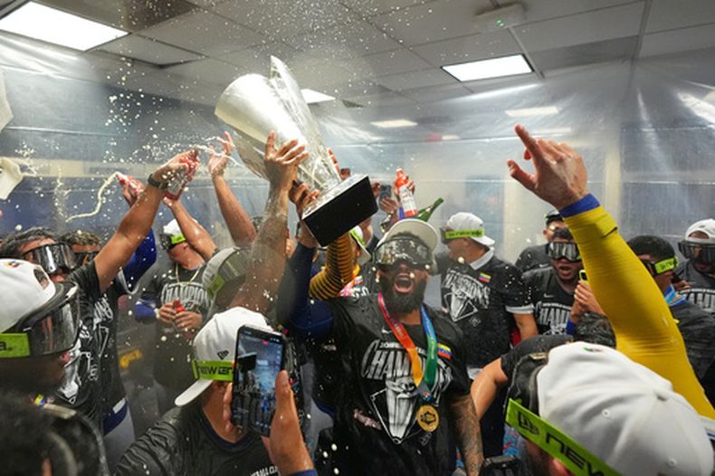 El equipo de Venezuela celebra con el trofeo tras derrotar a los Estados Unidos en el juego de campeonato del Clásico Mundial de Béisbol, el martes 17 de marzo de 2026, en Miami. (Foto AP/Rebecca Blackwell)