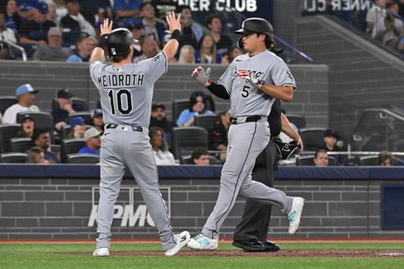 Chase Meidroth (10) y Munetaka Murakami (5), de los Medias Blancas de Chicago, celebran tras anotar gracias a un doblete de tres carreras de su compañero Colson Montgomery durante la quinta entrada de un partido de béisbol contra los Azulejos de Toronto en Toronto, el viernes 17 de julio de 2026. (Jon Blacker/The Canadian Press vía AP)
