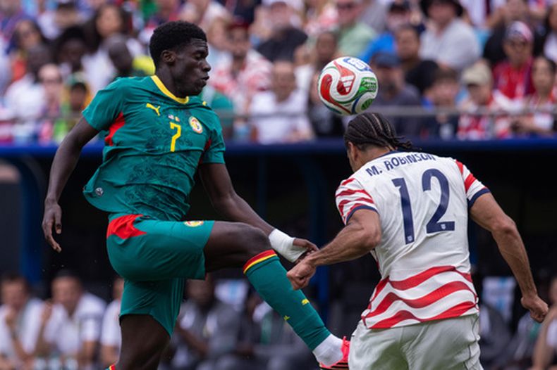 El defensa de los Estados Unidos, Miles Robinson (12), despeja el balón con la cabeza ante el delantero de Senegal, Assane Diao (7), durante la segunda mitad de un partido de fútbol amistoso internacional el domingo 31 de mayo de 2026, en Charlotte, Carolina del Norte. (Foto AP/Scott Kinser)