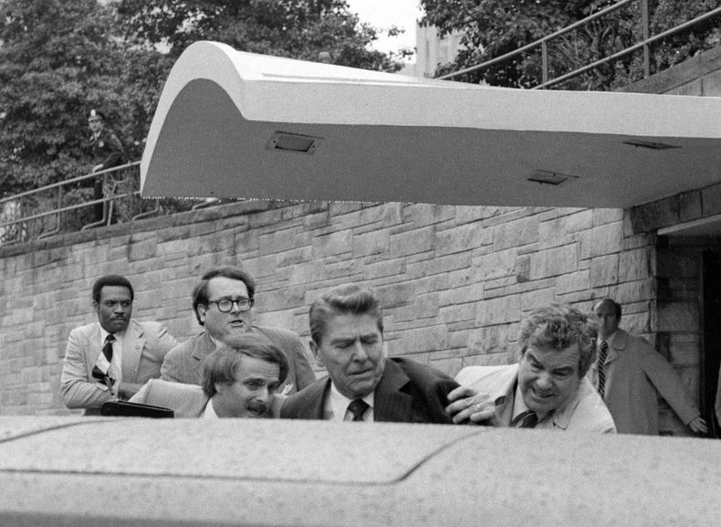 ARCHIVO - El presidente Ronald Reagan es empujado hacia su limusina por agentes del Servicio Secreto tras ser baleado el 30 de marzo de 1981, afuera de un hotel de Washington. (AP Foto/Ron Edmonds, archivo)