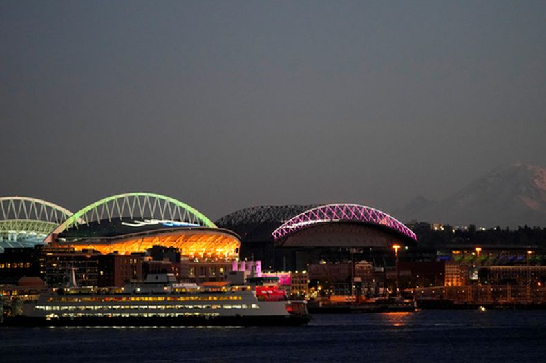 ARCHIVO - Foto del 29 de octubre del 2023, con imagen del ferry antes de llegar a la terminal en Seattle frente al Lumen Field y el T-Mobile Park. (AP Foto/Lindsey Wasson, Archivo)