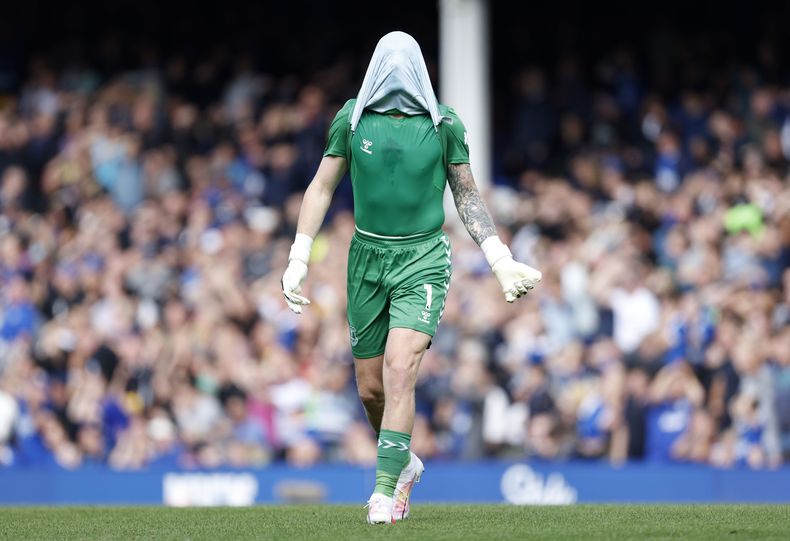 El portero del Everton Jordan Pickford se cubre el rostro con la camiseta en una muestra de frustración durante el partido de la Premier ante el Fulham, el sábado 12 de agosto de 2023, en Liverpool, Inglaterra. (Richard Sellers/PA via AP)
