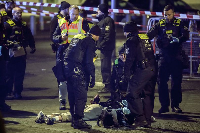 Agentes de la policía detienen a un hombre en el Memorial del Holocausto en Berlín, Alemania, luego de que otro hombre resultó gravemente herido al ser apuñalado por él, el viernes 21 de febrero de 2025. (AP Foto/Ebrahim Noroozi)