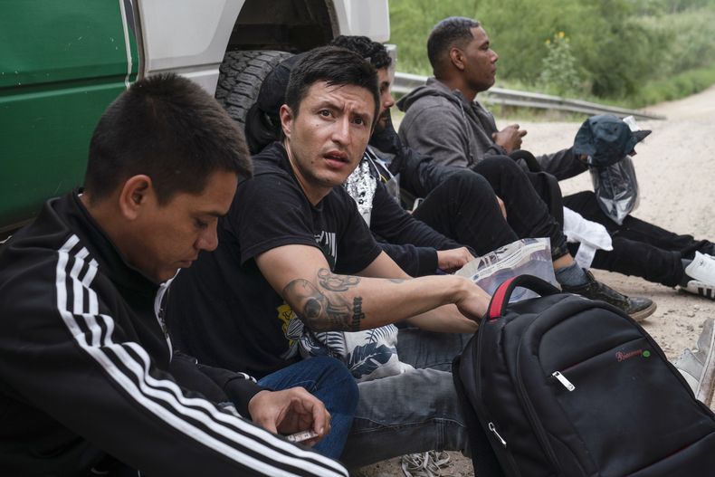 Migrantes colombianos que trataban de evadir a la Patrulla Fronteriza de Estados Unidos esperan para ser procesados cerca del punto de entrada en Hidalgo, Texas, el jueves 4 de mayo de 2023. La autoridad migratoria de Colombia suspendió la llegada de vuelos con migrantes colombianos deportados desde Estados Unidos, alegando los tratos degradantes que reciben los migrantes. (AP Foto/Veronica G. Cárdenas)