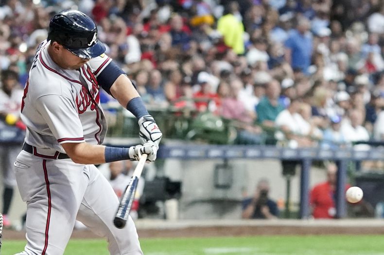 Austin Riley, de los Bravos de Atlanta, batea un sencillo en el quinto inning del juego ante los Cerveceros de Milwaukee, el viernes 21 de julio de 2023 (AP Foto/Morry Gash)