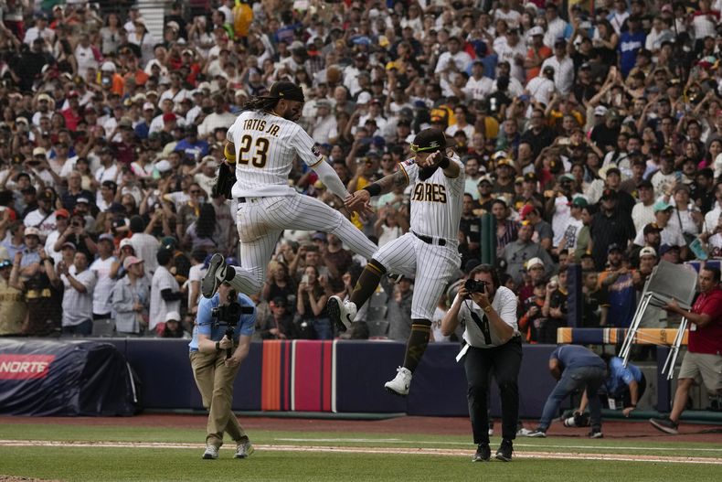 El jardinero derecho de los Padres de San Diego, Fernando Tatis Jr. (23), celebra con su compañero de equipo, Rougned Odor, después de que los Padres derrotaran 6-4 a los Gigantes de San Francisco en juego de béisbol el domingo 30 de abril de 2023, en Ciudad de México. (AP Foto/Fernando Llano)