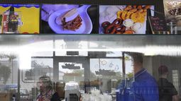 ARCHIVO - Empleados trabajan en una franquicia de Sabor Venezolano, uno de los 18 negocios propiedad de Wilmer Escaray que emplean a decenas de inmigrantes venezolanos con Estatus de Protección Temporal (TPS) en Doral, Florida, el 20 de mayo de 2025. (AP Foto/Rebecca Blackwell, Archivo)