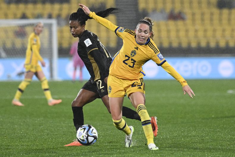 La futbolista sueca Elin Rubensson, a la derecha, y la sudafricana Jermaine Seoposenwe, compiten por el balón en su partido del Grupo G del Mundial de fútbol entre Suecia y Sudáfrica en Wellington, Nueva Zelanda, el domingo 23 de julio de 2023. (AP foto/Andrew Cornaga)