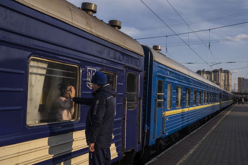 Ruslan Mishanin, de 36 años, se despide de su hija de 9 años mientras el tren con su familia se aleja rumbo a Polonia en la estación de tren de Odesa, el lunes 4 de abril de 2022. (AP Foto/Petros Giannakouris)