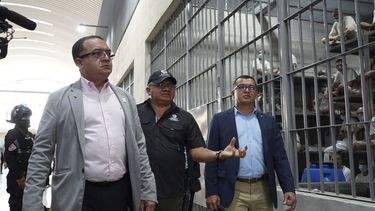 El ministro costarricense de Paz y Justicia, Gerald Campos Valverde, a la izquierda, en una visita en el Centro de Confinamiento del Terrorismo en Tecoluca, El Salvador, el viernes 4 de abril de 2025. (AP Foto/Salvador Meléndez)