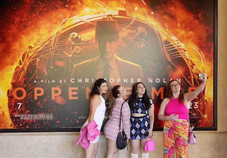 Gabrielle Roitman, de izquierda a derecha, Kayla Seffing, Maddy Hiller y Casey Myer se toman una selfie frente a un cartel de la película Oppenheimer antes de asistir a una proyección anticipada de Barbie, el jueves 20 de julio de 2023 en los cines AMC The Grove 14 en Los Ángeles. (Foto AP/Chris Pizzello)