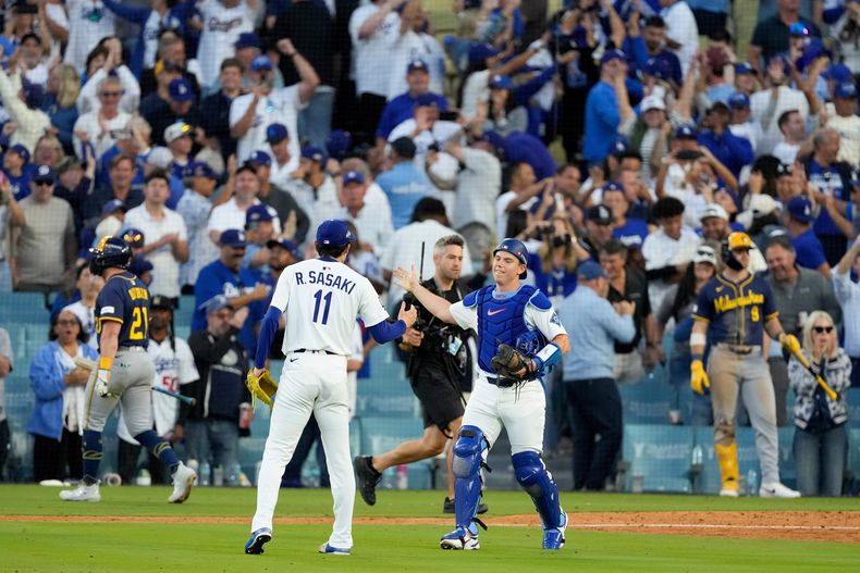 Roki Sasaki y Will Smith de los Dodgers de Los Ángeles celebran su victoria contra los Cerveceros de Milwaukee en el Juego 3 de la Serie de Campeonato de la Liga Nacional, el jueves 16 de octubre de 2025, en Los Ángeles. (AP Photo/Mark J. Terrill)