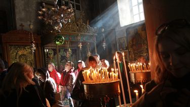 americateve | Fieles cristianos miran velas encendidas en la Iglesia de la Natividad, en la ciudad cisjordana de Bel&eacute;n, el lunes 23 de diciembre de 2013. (Foto AP/Nasser Shiyoukhi)