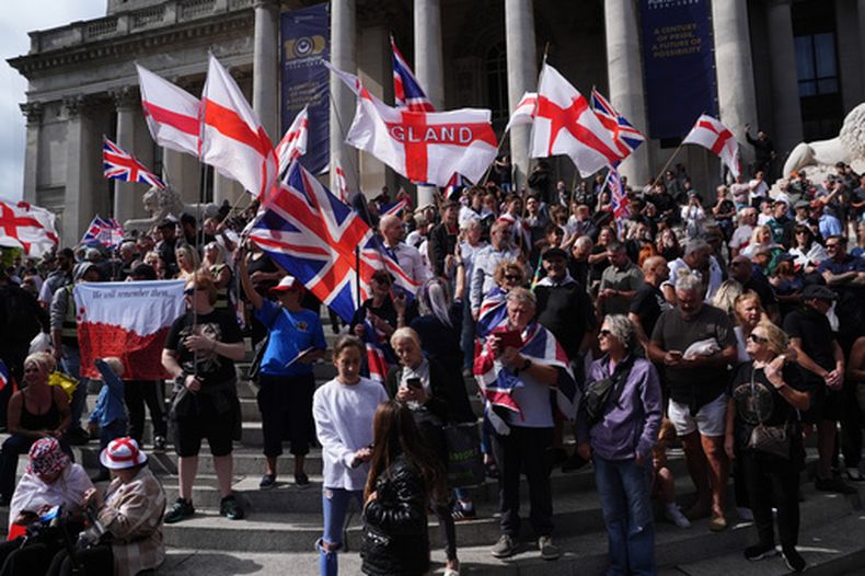Policía espera mientras un grupo de gente se congrega en el exterior del Portsmouth Guildhall, en Portsmouth, Inglaterra, para participar en una marcha antiinmigración, el 12 de septiembre de 2026. (Jonathan Brady/PA via AP)