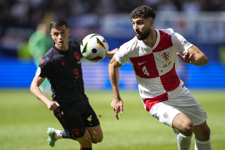 Josko Gvardiol de Croacia corre con el balón mientras lo persigue Jasir Asani de Albania en el encuentro del Grupo B de la Eurocopa el miércoles 19 de junio del 2024. (AP Foto/Ebrahim Noroozi)