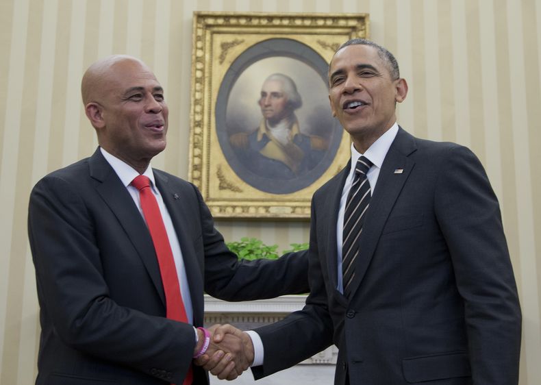 El presidente estadounidense Barack Obama y el mandatario haitiano Michel Martelly se saludan ante los fot&oacute;grafos junto a un retrato de George Washington en la Oficina Oval de la Casa Blanca, el jueves 6 de febrero de 2014, en Washington. (Foto AP/