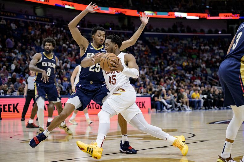 El armador de los Cavaliers de Cleveland Donovan Mitchell (45) conduce entre el armador de los Pelicans de Nueva Orleans Trey Murphy III (25) durante la segunda mitad del juego de baloncesto de la NBA, en Nueva Orleans, el miércoles 13 de marzo de 2024. (AP Foto/Matthew Hinton)