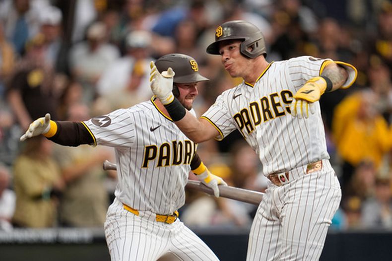 Freddy Fermin, derecha, de los Padres de San Diego, celebra con Jackson Merrill después de batear un cuadrangular durante la tercera entrada del juego de béisbol de Grandes Ligas contra los Rojos de Cincinnati el lunes 8 de junio de 2026, en San Diego. (AP Photo/Gregory Bull)