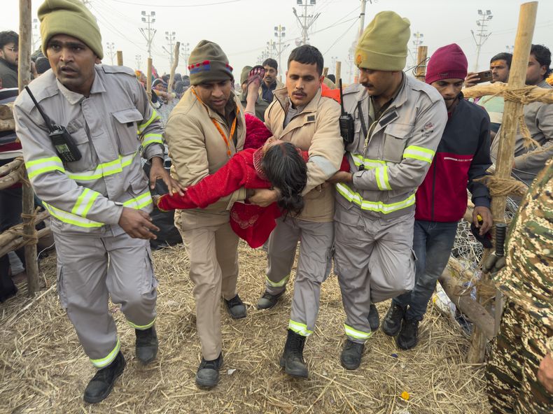 Agentes de seguridad sacan a una mujer del lugar de una estampida en el Sangam, la confluencia de los ríos Ganges, Yamuna y Saraswati, en el Mauni Amavasya o día de luna nueva durante el festival Maha Kumbh, en Prayagraj, Uttar Pradesh, India, el 29 de enero de 2025. (AP Foto/Rajesh Kumar Singh)