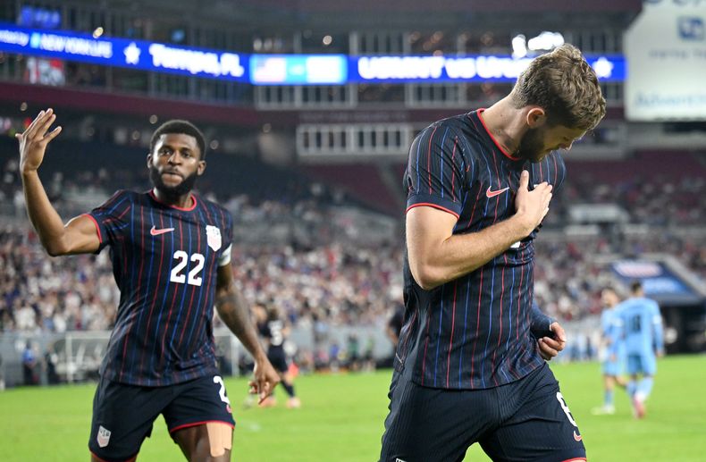 Mark McKenzie (22) y Tanner Tessman, de la selección de Estados Unidos, festejan el gol del segundo ante Uruguay, en un partido amistoso efectuado el martes 18 de noviembre en Tampa, Florida (AP Foto/Jason Behnken)