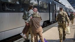 Un militar ucraniano abraza a su esposa y a su hija al despedirse de ellas para irse a combate en la estación de tren de Sloviansk, Ucrania, el 12 de septiembre de 2023. (Foto AP/Hanna Arhirova)
