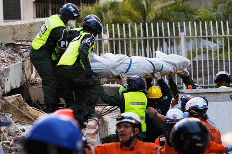 Rescatistas transportan un cuerpo recuperado de los escombros de un edificio derrumbado en Caracas, Venezuela, el viernes 26 de junio de 2026, dos días después de que dos terremotos consecutivos sacudieran el país. (AP Foto/Pedro Mattey)